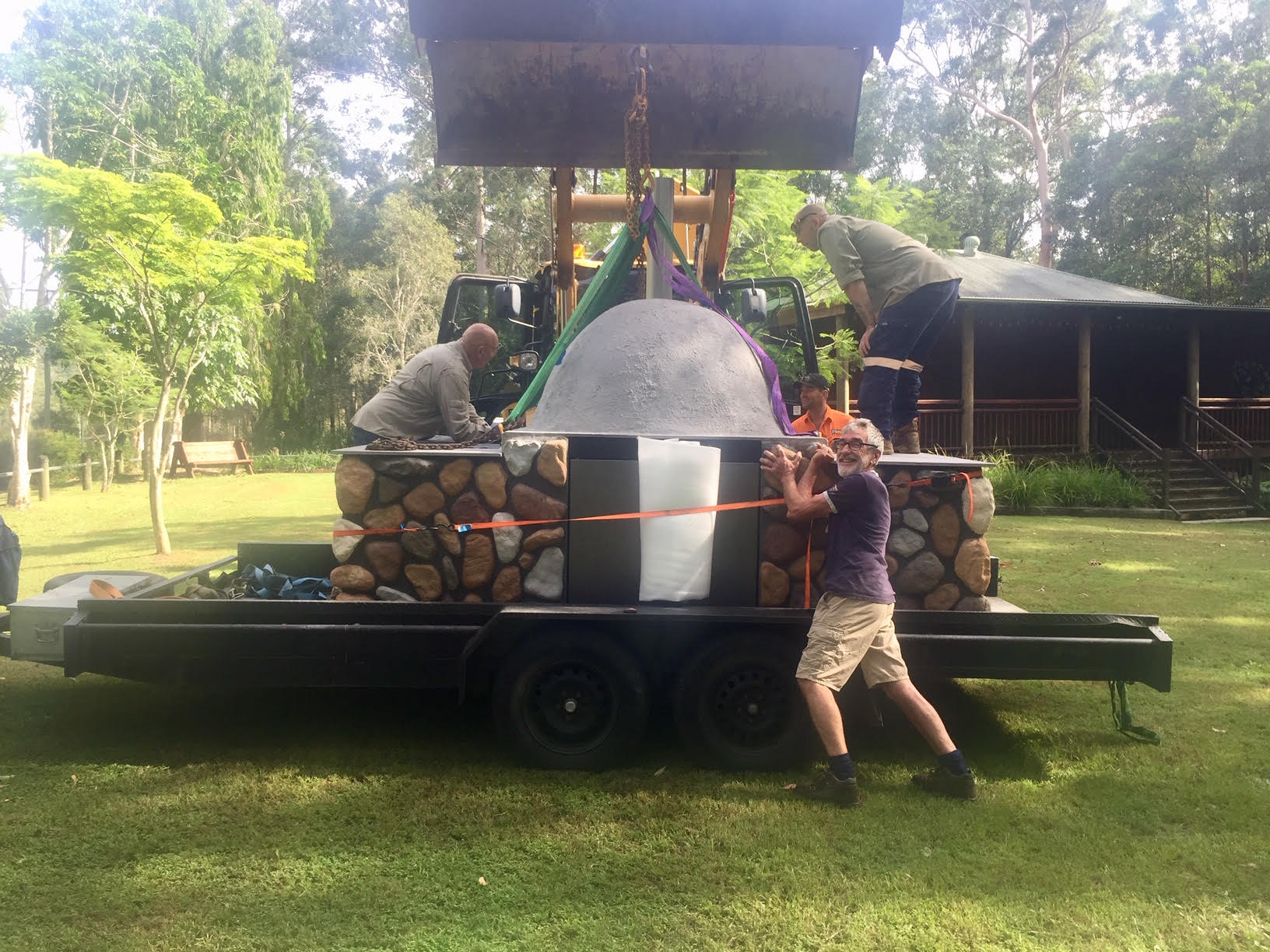 Man placing cap on pizza oven chimney